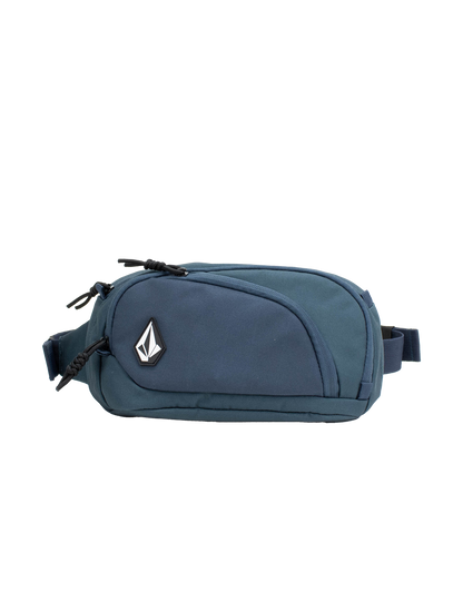 The Volcom Men's Waisted Pack is a blue waist pack featuring a front zipper pocket, black zipper pulls, and a distinctive black-and-white geometric Volcom logo on the front. Designed for outdoor adventures and hands-free convenience, it is displayed against a plain white background.