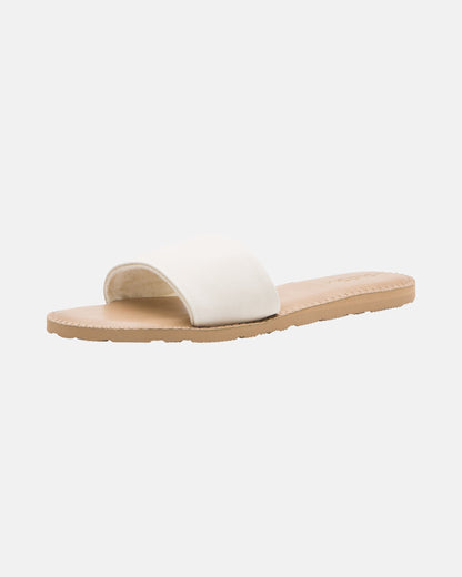 The Volcom Women's Simple Slide is a minimalist sandal with a wide white strap and flat light tan sole, shown on a plain white background.
