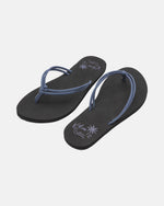 The Volcom Women's Forever And Ever II flip-flops feature black soles with thin blue straps and decorative writing plus palm tree graphics on the insoles, shown against a plain white background.
