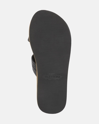 The bottom view of the Women's Volcom Double Cross Sandals by Volcom shows a black sandal with a textured rubber sole featuring fine horizontal grooves for traction.
