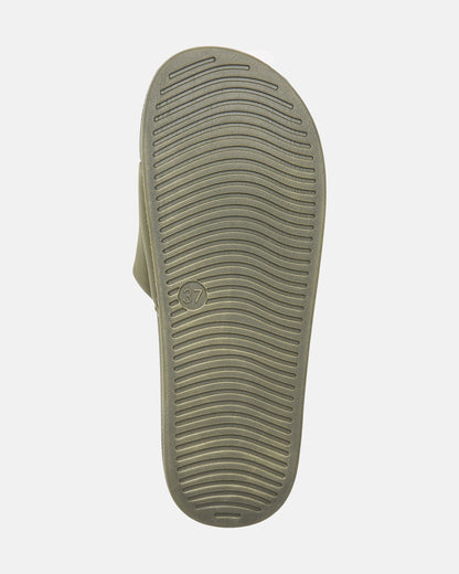 The image shows the sole of Volcom Women's Volcation Slides, featuring curved horizontal grooves for grip and a small circle with the number 37 near the arch, combining signature Volcom style with everyday comfort.