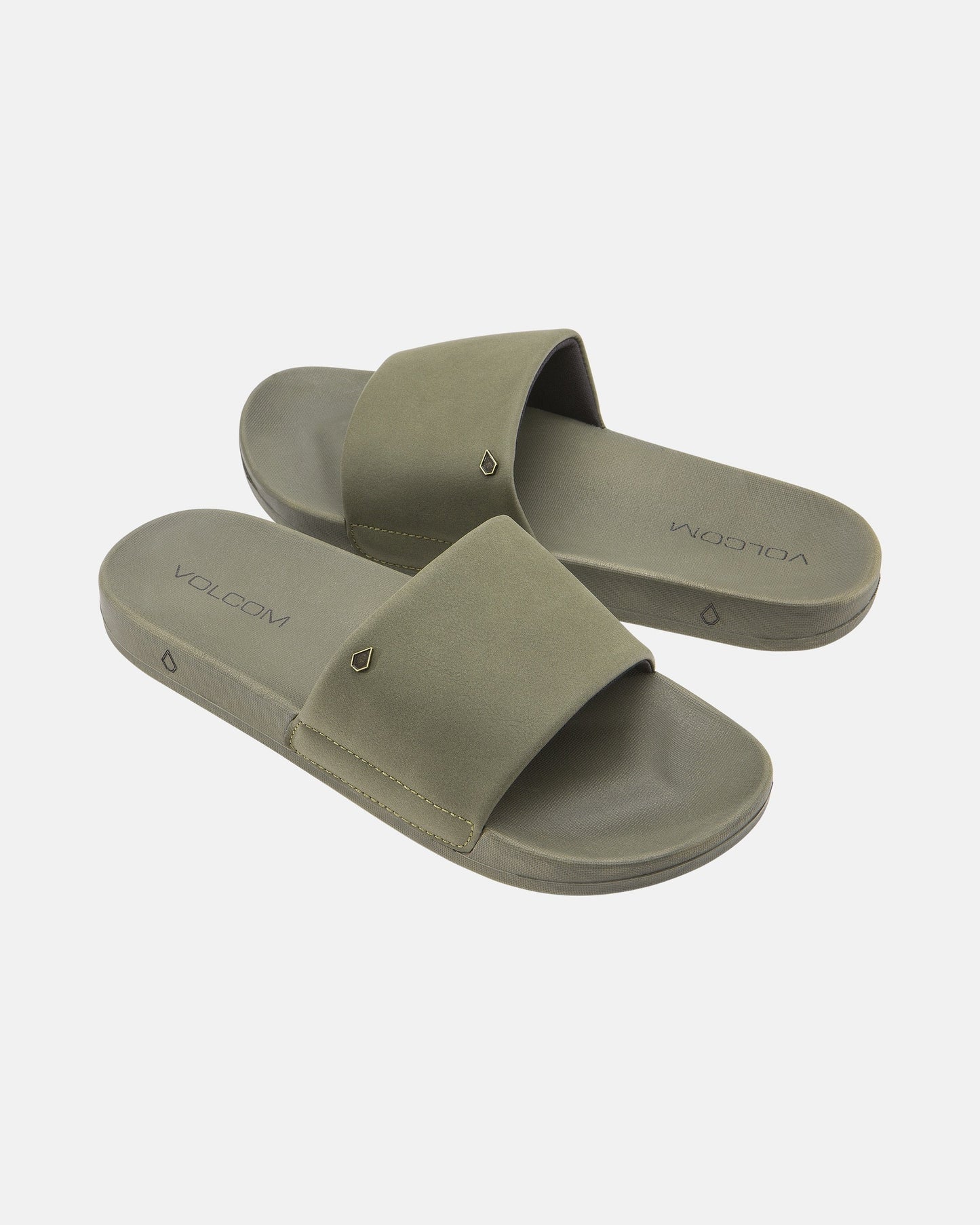 The Women's Volcom Volcation Slides feature olive green wide straps and flat soles, offering everyday comfort and classic Volcom style, shown against a white background.