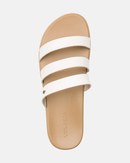 The Volcom Women's Sunseeker Sandals feature a tan base with three white horizontal straps and "VOLCOM" embossed on the footbed, shown from above against a light background.
