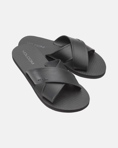 The Women's Volcomotion Strap Sandals by Volcom feature black crisscross straps and textured soles, with the brand name visible on the straps and footbeds, displayed against a plain white background.