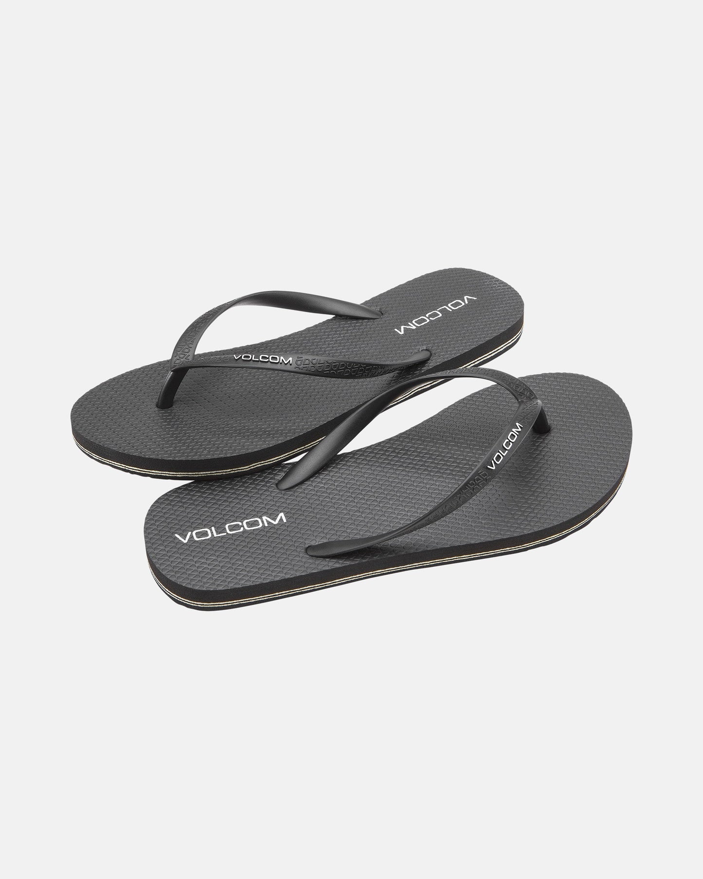 The Women's Volcomotion Womens by Volcom are black flip-flops with thin straps, simple textured soles, and white Volcom logos, providing everyday comfort. Displayed on a white background, these summer sandals are perfect for daily wear.