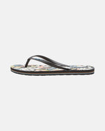 The Women's Volcomotion Womens by Volcom is a single flip-flop sandal with black straps and a vibrant floral-patterned footbed, shown in side profile on white, delivering everyday comfort and signature Volcom style.