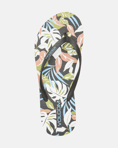 The Women's Volcomotion Womens sandal by Volcom features a black strap and a vibrant tropical leaf print in green, blue, peach, and white, with the VOLCOM logo on the strap and footbed for signature style.
