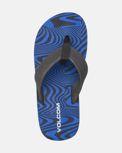 A single blue and black Kids' Daycation 2 Big Youth flip-flop by Volcom features a wavy, abstract pattern, black straps, white VOLCOM branding on the footbed, Recliner Comfort Foam, and arch support for all-day comfort.